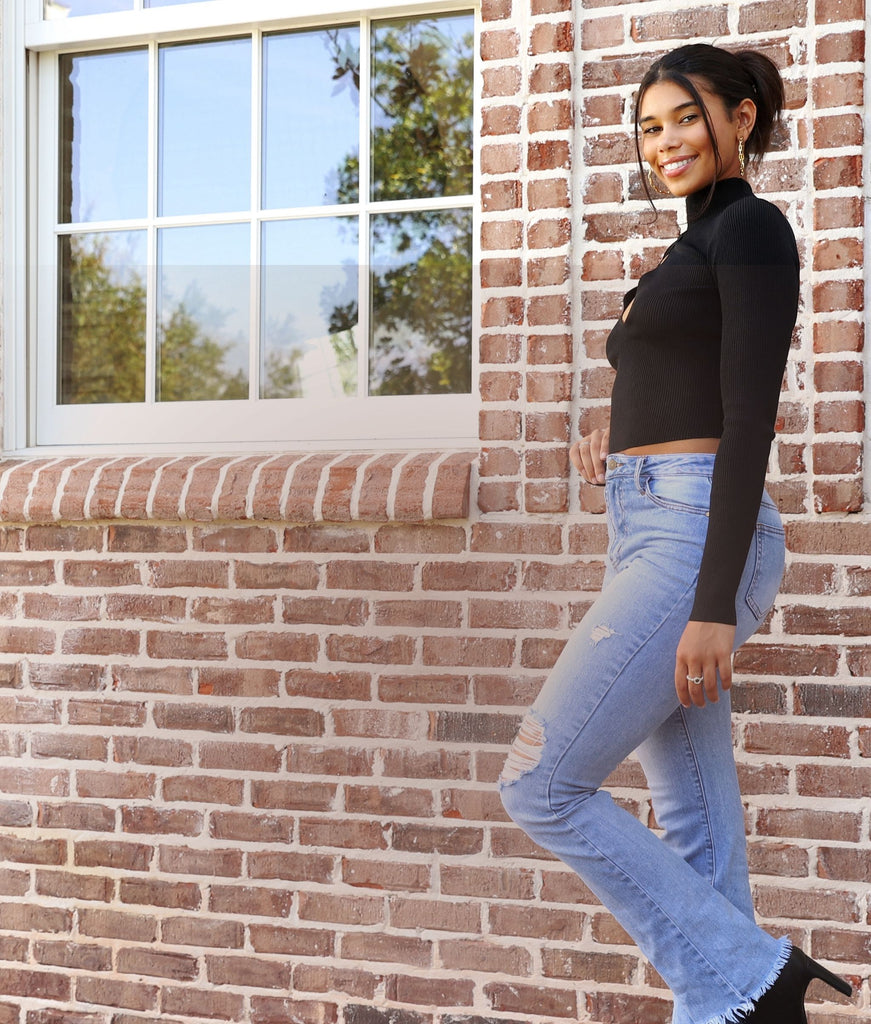 Mobile image of woman wearing avenue des champs outfit, Ciao Babe Ribbed Mock Neck Cutout Top, standing in front of a brick wall